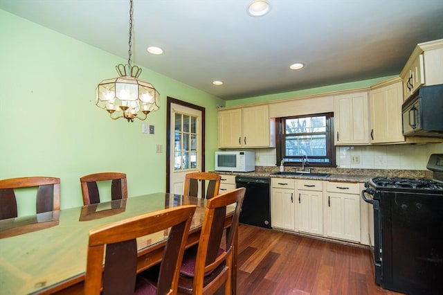 kitchen with sink, hanging light fixtures, dark wood-type flooring, a notable chandelier, and black appliances