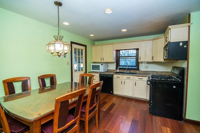 kitchen with black appliances, sink, hanging light fixtures, dark hardwood / wood-style flooring, and a chandelier