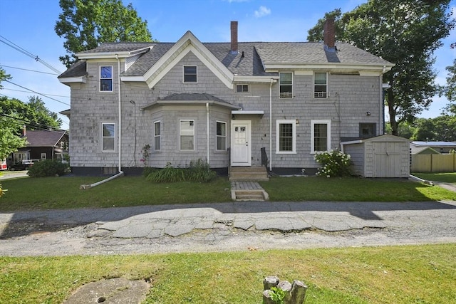619 Crescent St, Brockton, MA 02302 - view of front of home with a shed, a front yard, a chimney, and a shingled roof