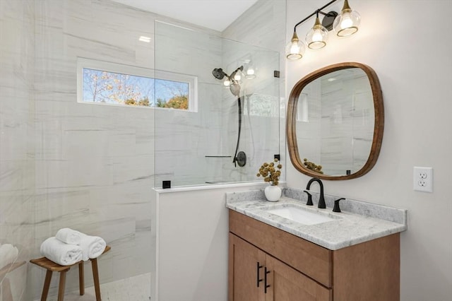 bathroom with tiled shower and vanity