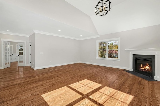 unfurnished living room with french doors, ornamental molding, vaulted ceiling, hardwood / wood-style flooring, and a chandelier