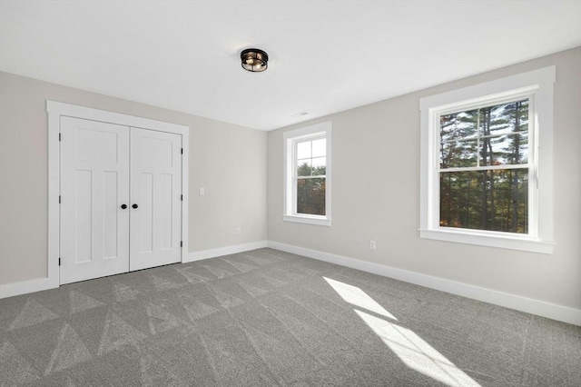 unfurnished bedroom featuring carpet flooring and a closet