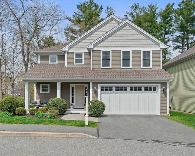 view of front of property featuring a garage, a porch, a shingled roof, and driveway