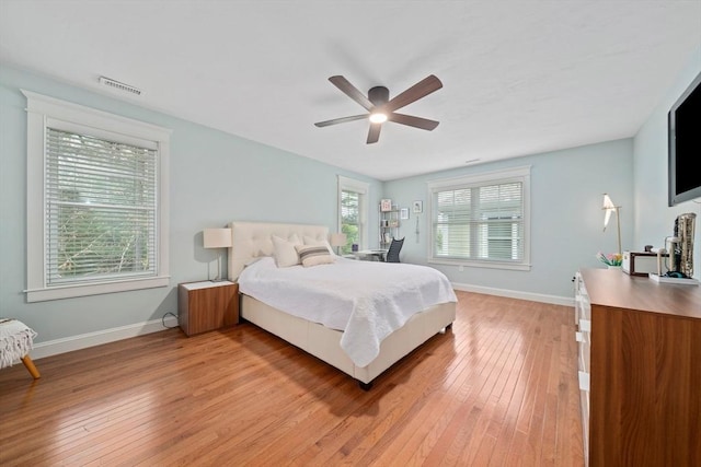 bedroom with baseboards, ceiling fan, light wood-type flooring, and visible vents