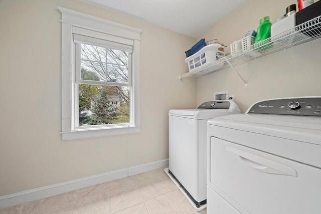 laundry room featuring laundry area, baseboards, light tile patterned floors, and separate washer and dryer