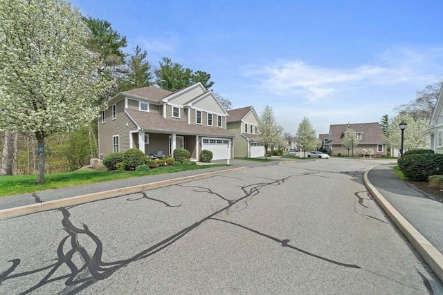 view of street featuring street lighting, curbs, sidewalks, and a residential view
