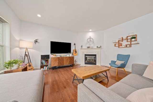 living room with a fireplace with flush hearth, baseboards, recessed lighting, and wood finished floors