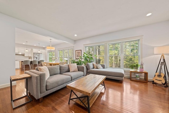 living area featuring baseboards, recessed lighting, and hardwood / wood-style floors