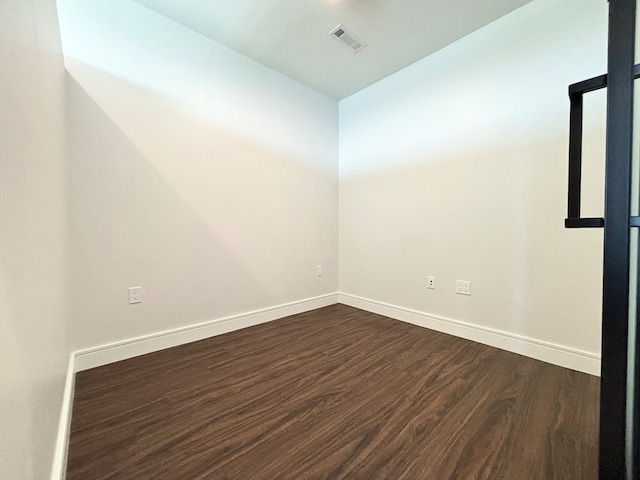 unfurnished room with dark wood-type flooring