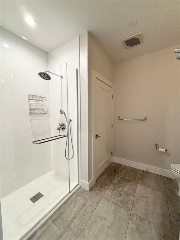 bathroom with a shower, tile flooring, and toilet