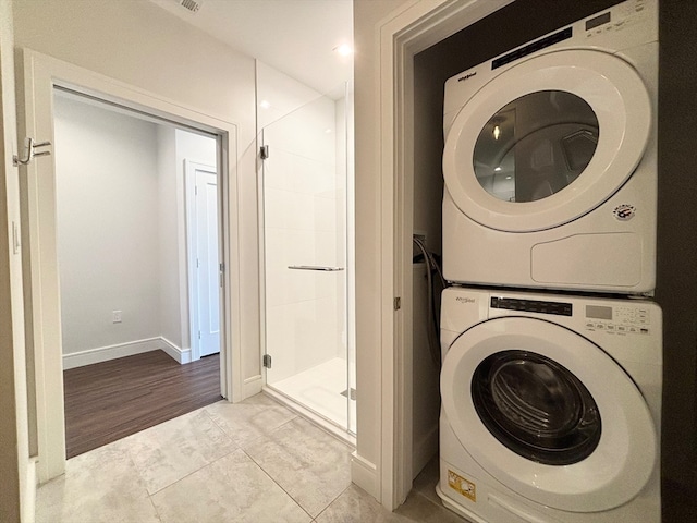 washroom with hookup for a washing machine, light hardwood / wood-style flooring, and stacked washer and clothes dryer