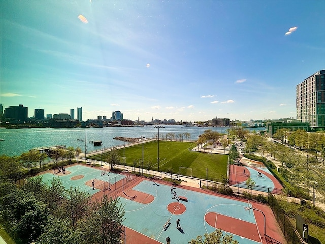 exterior space with basketball hoop and a water view