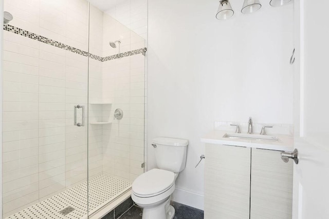 bathroom featuring toilet, baseboards, a shower stall, and vanity