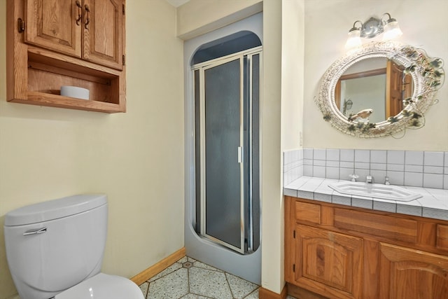 bathroom with a shower with shower door, vanity, and toilet