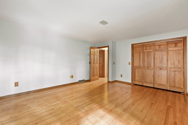 unfurnished bedroom with a closet and light wood-type flooring