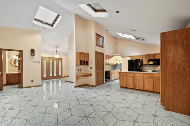 kitchen featuring high vaulted ceiling, black appliances, a skylight, decorative light fixtures, and backsplash