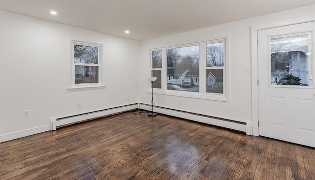 empty room with dark wood-type flooring and a baseboard radiator