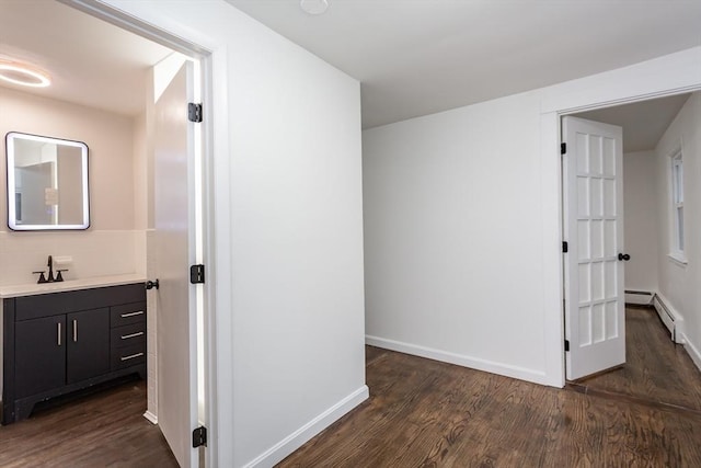 hallway with dark hardwood / wood-style flooring and a baseboard heating unit