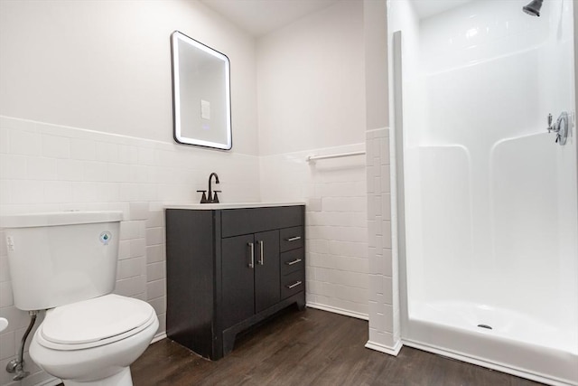 bathroom with hardwood / wood-style floors, vanity, toilet, and tile walls