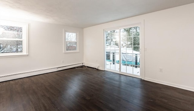 unfurnished room with dark hardwood / wood-style floors, a wealth of natural light, and a baseboard heating unit