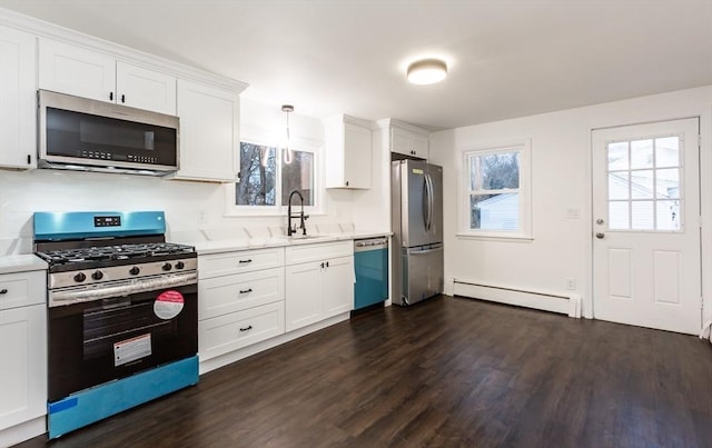 kitchen with white cabinets, pendant lighting, stainless steel appliances, and baseboard heating