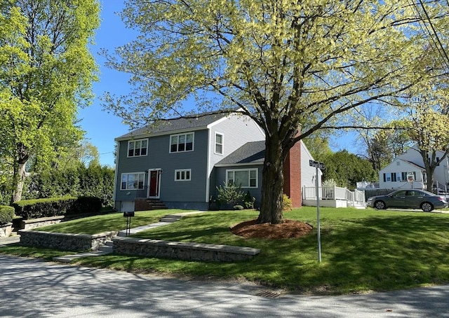 colonial inspired home featuring entry steps and a front yard