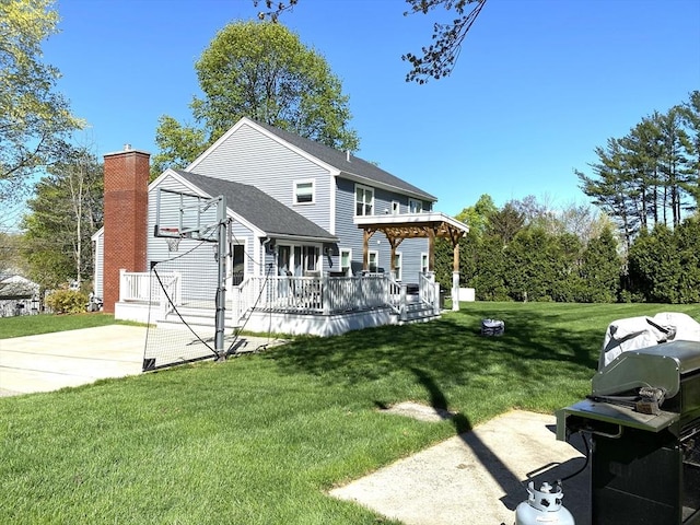 view of front of property featuring a wooden deck, a chimney, and a front lawn