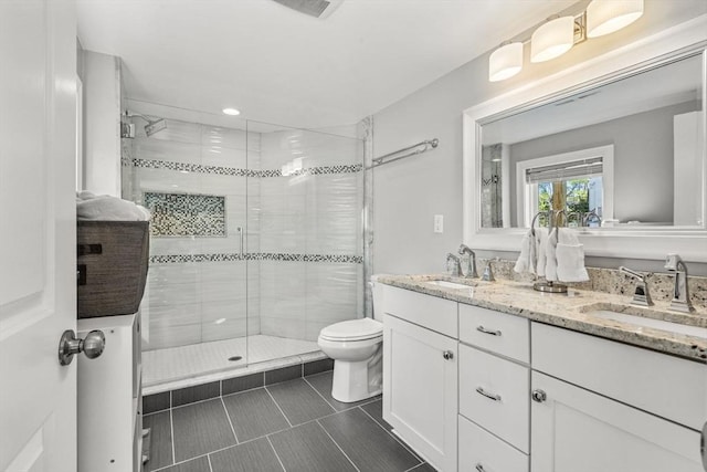 bathroom with toilet, tile patterned floors, a shower stall, and a sink