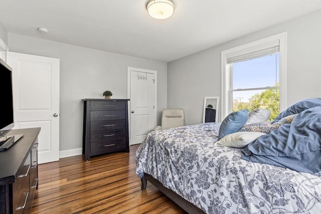 bedroom featuring baseboards and dark wood-type flooring