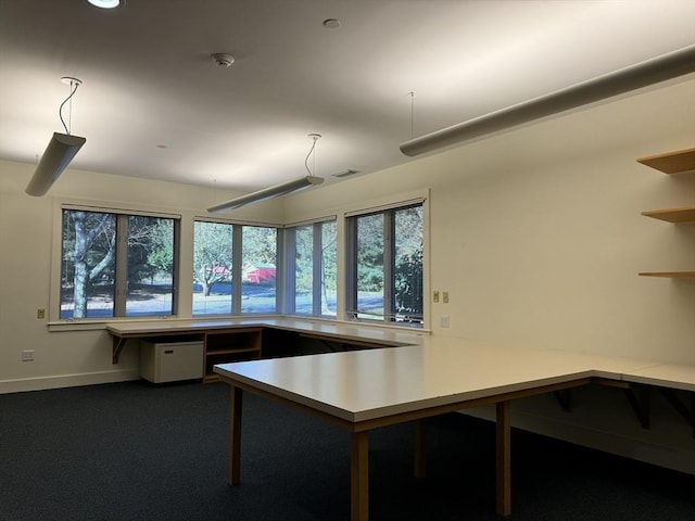 interior space with light countertops, carpet flooring, visible vents, and baseboards