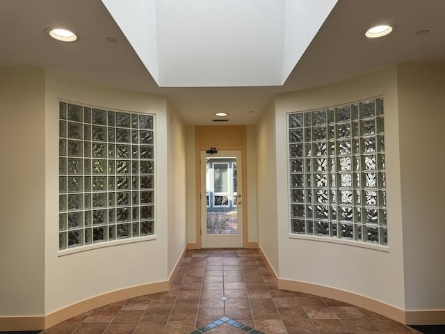 doorway to outside with baseboards, dark tile patterned flooring, and recessed lighting