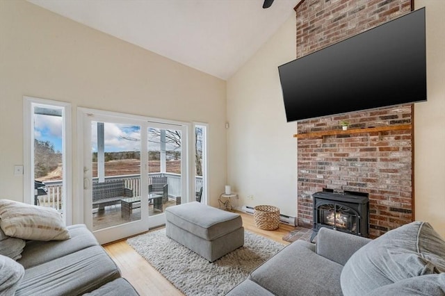 living room featuring high vaulted ceiling, a fireplace, and light wood-type flooring