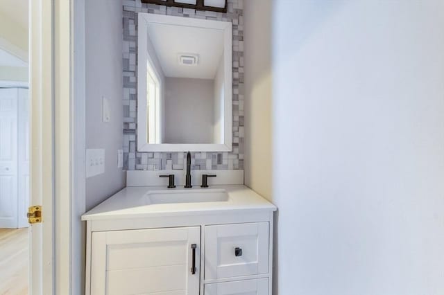 bathroom featuring vanity, visible vents, and decorative backsplash