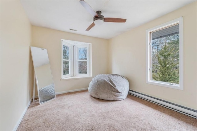 sitting room with visible vents, a healthy amount of sunlight, a ceiling fan, and baseboard heating