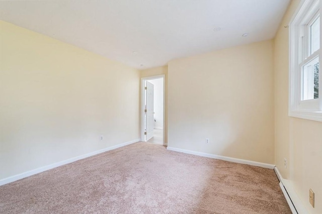 carpeted empty room featuring a baseboard radiator and baseboards