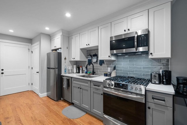 223 Saratoga St Unit U203, Boston, MA 02128 - kitchen featuring appliances with stainless steel finishes, gray cabinetry, a sink, light countertops, and decorative backsplash