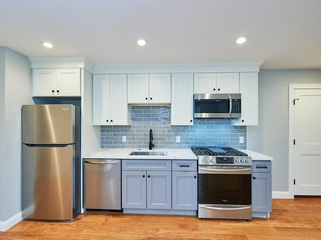 223 Saratoga St Unit U203, Boston, MA 02128 - kitchen featuring appliances with stainless steel finishes, a sink, light countertops, tasteful backsplash, and light wood finished floors