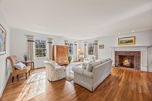 living room featuring hardwood / wood-style floors and a brick fireplace