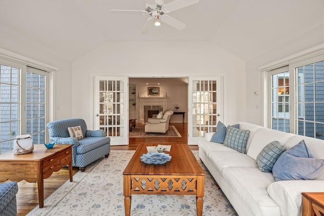 living room featuring ceiling fan, vaulted ceiling, and light hardwood / wood-style flooring