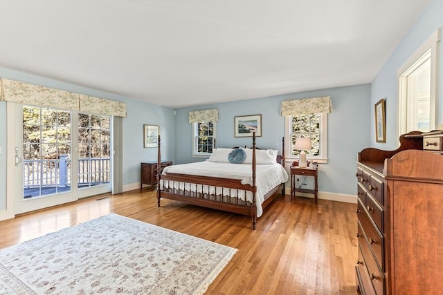 bedroom featuring access to exterior and light hardwood / wood-style flooring