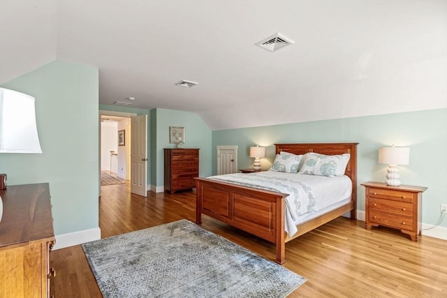 bedroom featuring lofted ceiling and light wood-type flooring