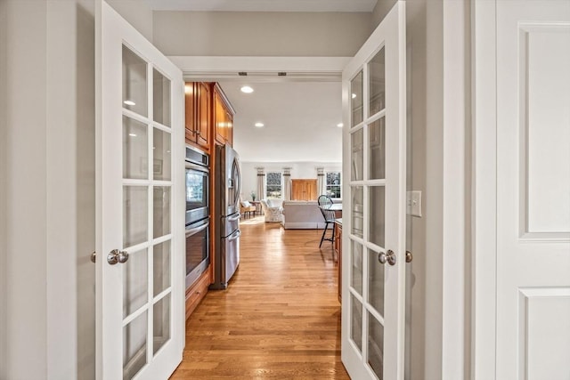 hallway featuring french doors and light wood-type flooring