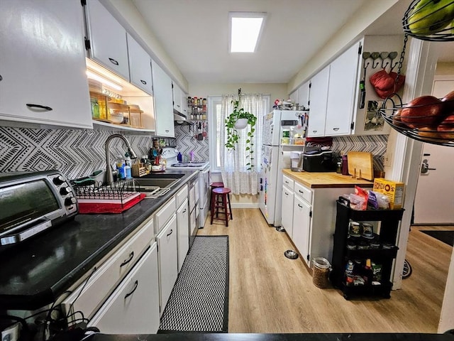 12 Sutton Ct Unit 12, Amherst, MA 01002 - kitchen with electric range, light wood-style floors, white cabinetry, freestanding refrigerator, and a sink