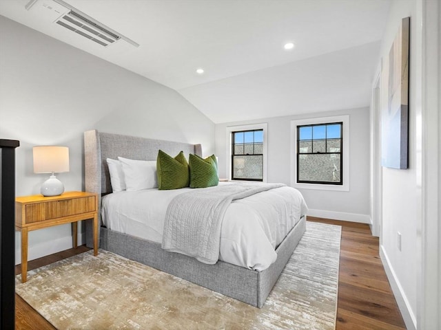 bedroom with hardwood / wood-style floors and lofted ceiling