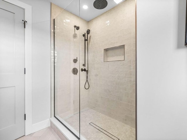 bathroom featuring tile patterned flooring and a tile shower