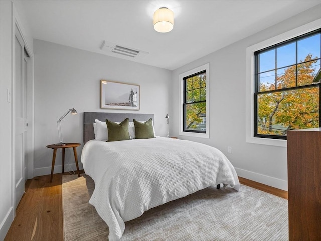 bedroom with a closet and hardwood / wood-style floors