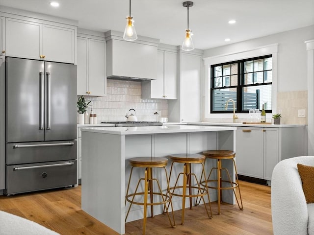 kitchen featuring appliances with stainless steel finishes, light wood-type flooring, white cabinetry, and a breakfast bar area