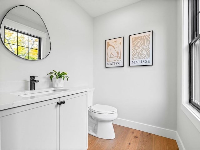 bathroom featuring wood-type flooring, vanity, and toilet