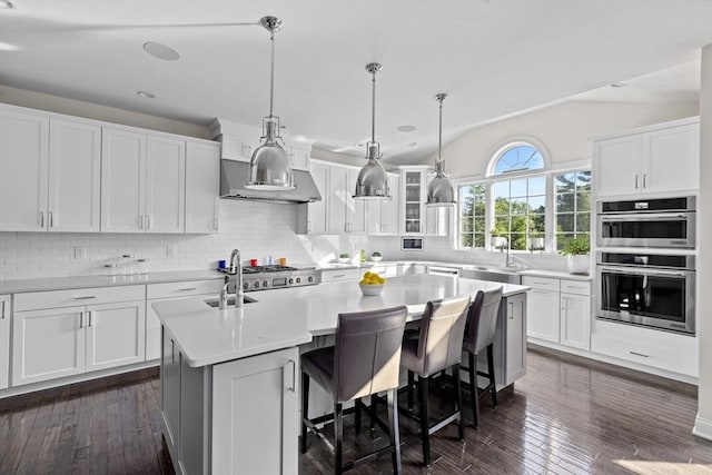 kitchen with light countertops, a center island with sink, and white cabinets