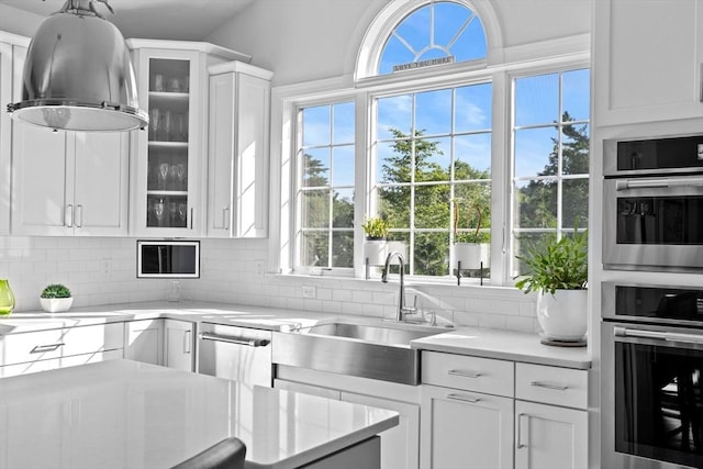 kitchen featuring white cabinetry, glass insert cabinets, and light countertops